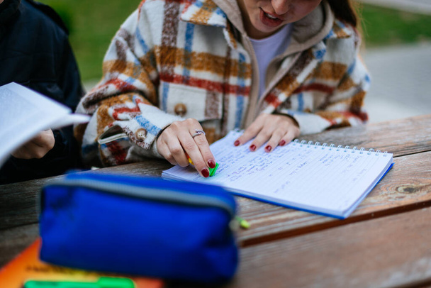 Eine Gymnasiastin hat beim Schreiben ihrer Hausaufgaben einen Fehler gemacht. Sie benutzt Gummi, um die Fehler zu beseitigen - Foto, Bild