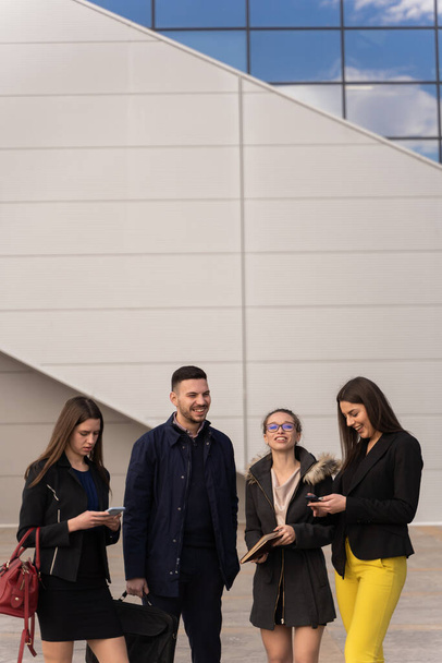 Gruppe junger Geschäftsleute lacht gemeinsam draußen vor der Firma - Foto, Bild