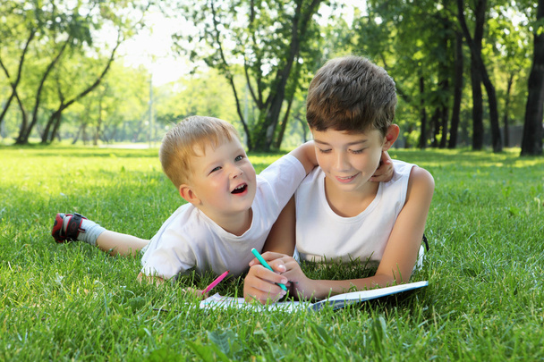 Children in the park reading a book - Photo, Image