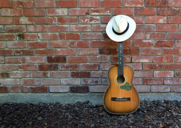 Μουσικός παίρνει ένα διάλειμμα - κιθάρα, άρπα και καπέλο Παναμά  - Φωτογραφία, εικόνα