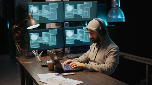 Hacker kodér hacking systém v noci pomocí viru produkovat počítačový malware a chybu serveru. Zloděj dat krade informace ze softwarové aplikace, pracuje s více monitory. Ruční snímek. - Fotografie, Obrázek