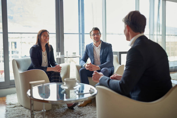 Їхній зворотній зв'язок безцінний. три бізнесмени розмовляють у корпоративному офісі
 - Фото, зображення