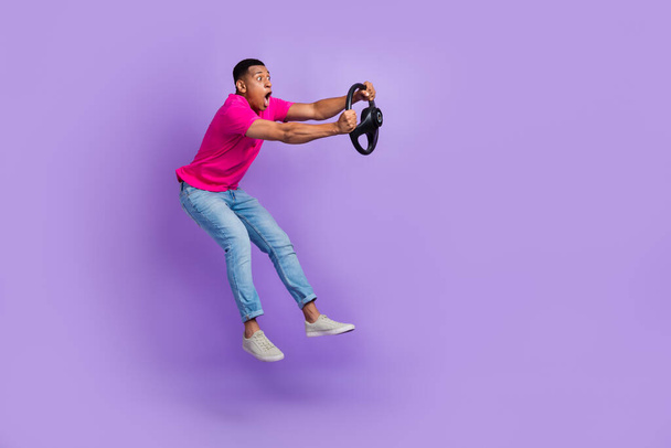 Full size profile photo of impressed person jumping arms hold wheel isolated on violet color background. - Fotoğraf, Görsel