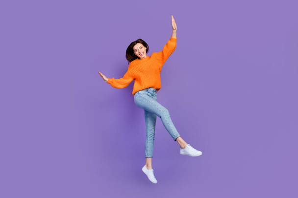 Фотографія красивої молодої жінки, що танцює, мають веселий одяг модний помаранчевий трикотажний одяг ізольований на фіолетовому кольоровому фоні
 - Фото, зображення