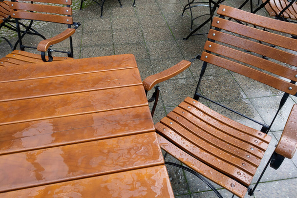 Meubles d'extérieur vides après la pluie sur la terrasse du café - Photo, image