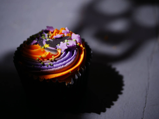 Halloween-Cupcake mit gespenstischem Gesichtsschatten mittlerer Schuss selektiver Fokus - Foto, Bild
