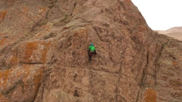 Man Climber Felsklettern. Klippen in Tamgaly Tas, Kasachstan. Luftaufnahme. Umlaufbahn - Filmmaterial, Video
