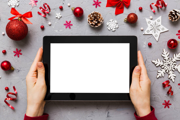 Christmas online shopping from home, female hands holding tablet pc with blank white display top view. woman hand holding tablet with blank screen, Christmas tree and gifts on background. - Foto, Imagem