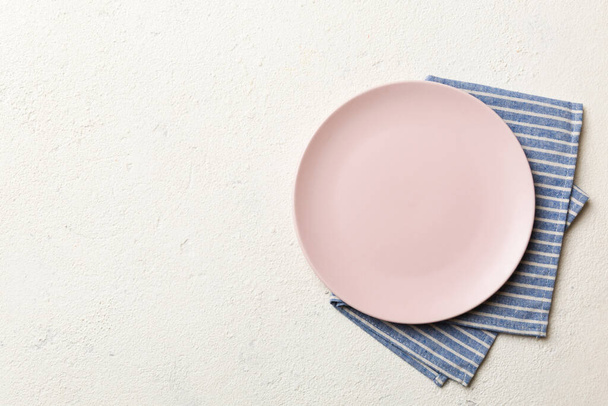 Felülnézeti színes háttér üres kerek rózsaszín lemez asztalterítő élelmiszer. Üres tál szalvétán helyet a design. - Fotó, kép