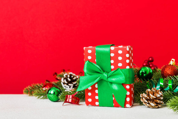 Новорічний різдвяний настрій, подарункова коробка, гілки христми, новорічні прикраси на кольоровому тлі.. - Фото, зображення
