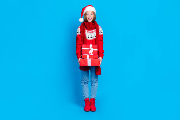 Full length photo of sweet excited school girl wear red xmas ornament sweater getting presents stack pile isolated blue color background. - Foto, immagini