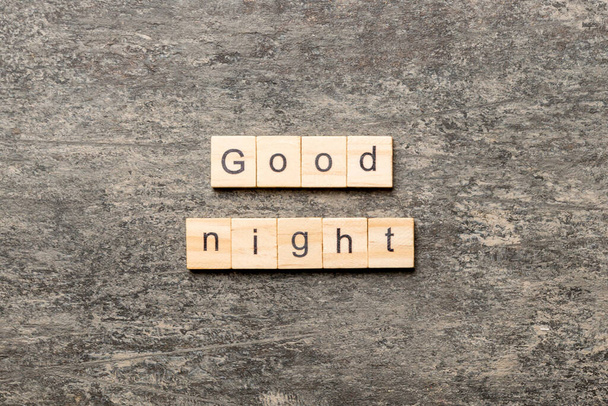 Buenas noches, palabra escrita en madera. buen texto de la noche en la mesa, concepto. - Foto, Imagen