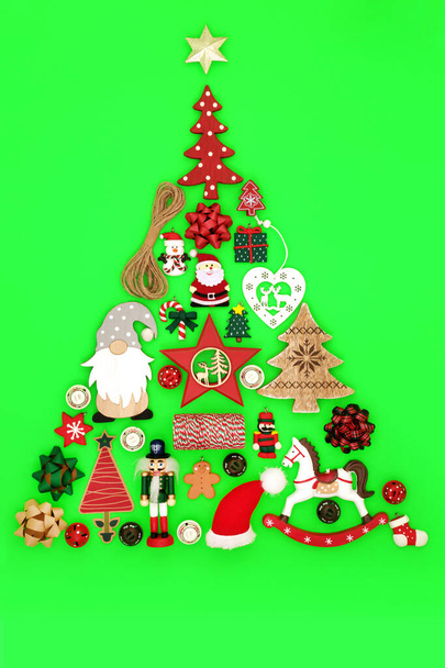 素朴なレトロな昔ながらの装飾が施されたクリスマスツリーの形の装飾コンセプト。緑の背景にクリスマスと新年の休暇シーズンのための環境に優しい最小限のデザイン. - 写真・画像