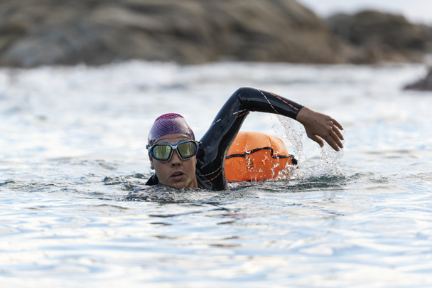 Portrét ženy plavající v otevřené vodě s neoprénem a bójí - Fotografie, Obrázek
