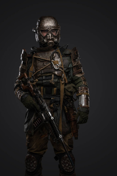 Colpo di soldato post apocalittico vestito in armatura e maschera antigas con fucile in mano. - Foto, immagini