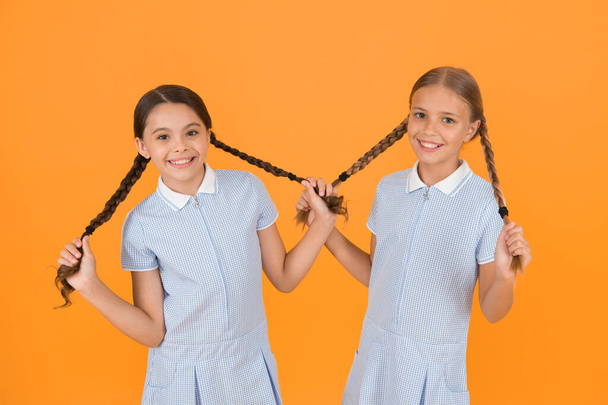 Looking trendy. sisterhood concept. best friends. vintage style. small girls in retro uniform. old school fashion. back to school. happy beauty with pigtails. happy childhood. brunette and blond hair. - Foto, afbeelding