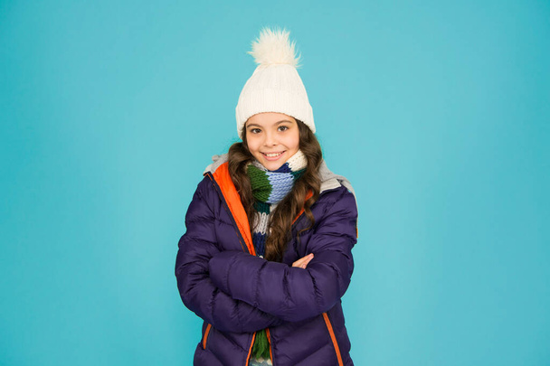 Keep your baby really warm whilst active. Happy baby girl with confident smile. Little baby keep arms crossed blue background. Small baby enjoy casual winter style. Fashion and style. - Valokuva, kuva