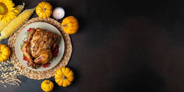Happy Thanksgiving holiday background. Roasted whole chicken or turkey with autumn vegetables for thanksgiving dinner on dark background, copy space - Φωτογραφία, εικόνα