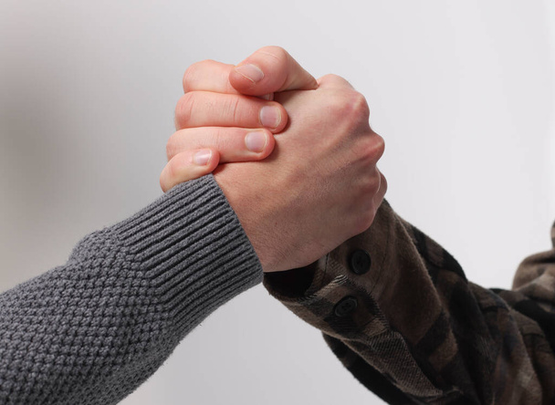 Nahaufnahme zweier gefalteter Hände als Zeichen der Übereinstimmung, Freundschaft oder Brüderlichkeit - Foto, Bild