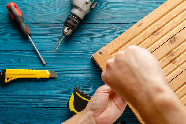 Handyman in blue uniform works with electricity automatic screwdriver. House renovation conception. - Foto, Imagen