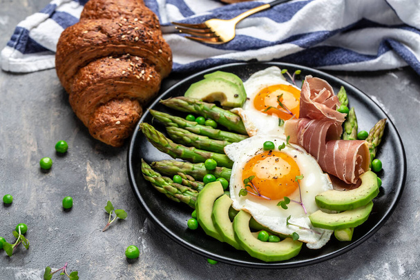 τηγανητό αυγό με σπαράγγια και προσούτο. Νόστιμο πρωινό ή σνακ, καθαρή διατροφή, δίαιτα, vegan έννοια των τροφίμων. πάνω όψη. - Φωτογραφία, εικόνα