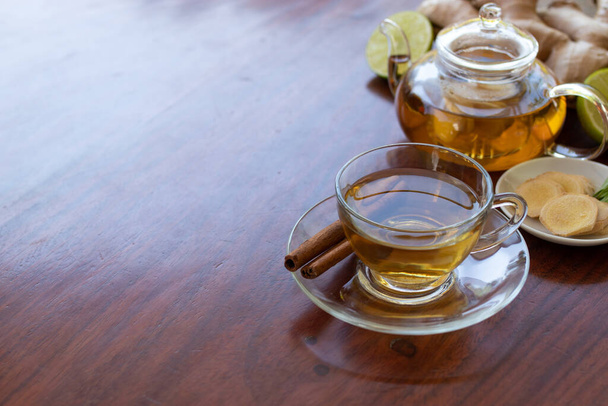 a cup of tea with ginger root, lime, cinnamon and teapot on white background. Health drink concept. - Photo, Image