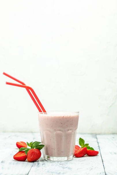 smoothie with berries. Strawberry smoothie or milkshake with berries and yogurt in glass jar on white background. Vegetarian healthy drink. - Foto, Imagen