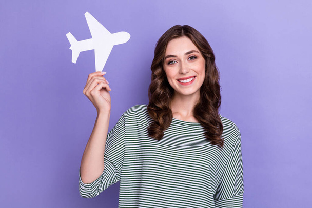 Zdjęcie pozytywne wesoły glamour pani ręka trzymać papier karty samolot reklamować usługi biura podróży izolowane na fioletowym tle kolor. - Zdjęcie, obraz