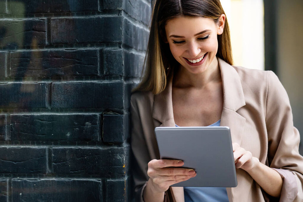 Portrait of young successful woman using digital tablet in urban background. Business people concept - Φωτογραφία, εικόνα