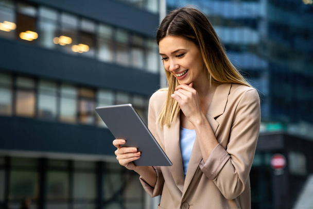 Portrait of young successful woman using digital tablet in urban background. Business people concept - Fotografie, Obrázek