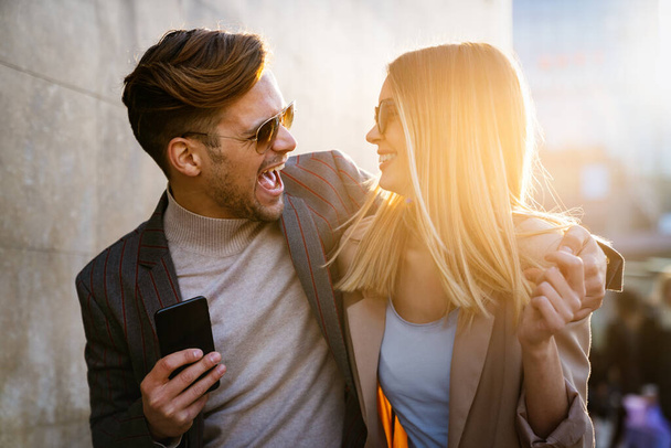 Happy successful business couple in love having fun together in urban background. People business travel shopping love concept. - Фото, изображение