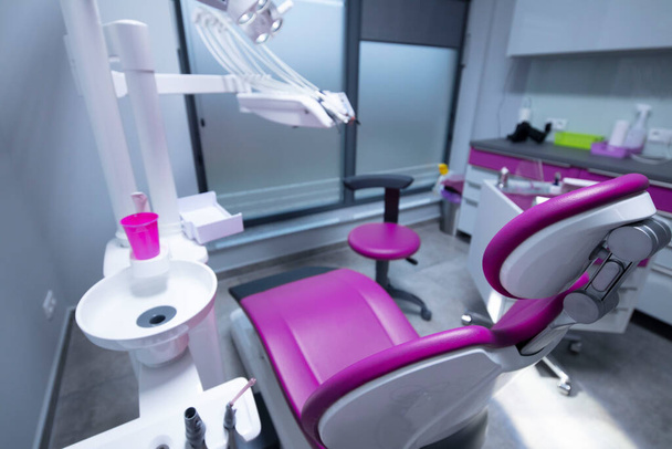 Современная стоматологическая практика. Стоматологическое кресло и другие принадлежности, используемые стоматологами. - Фото, изображение