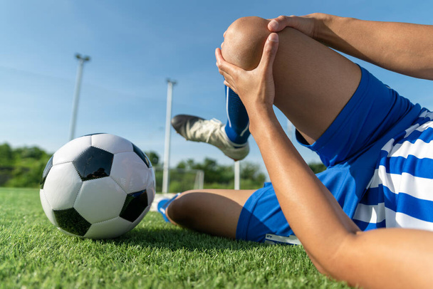 Atleta de pie con pelota en el campo de fútbol durante el amanecer, pelota de fútbol en la red en el fondo del cielo, movimiento de la bola, deportes populares en el club de fútbol. - Foto, Imagen