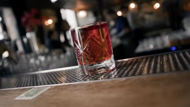 Gros plan - Negroni cocktail prêt se tient sur le bar et attend l'invité - Séquence, vidéo