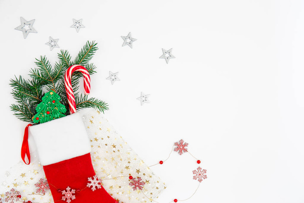 Χριστουγεννιάτικη κάλτσα με εορταστικές διακοσμητικές λεπτομέρειες σε λευκό φόντο απομονωμένη, αντίγραφο χώρου. - Φωτογραφία, εικόνα
