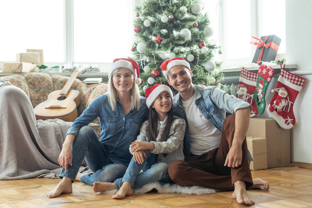 family having fun and playing together near Christmas tree indoors - Foto, Imagem