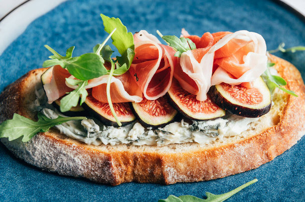 Sandwich ouvert au fromage bleu, Figues, feuilles de salade de fusée et prosciutto - Photo, image