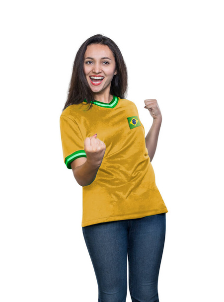 Young beautiful fan in a yellow t-shirt of the Brazil national team celebrating a goal happy and excited on white background. - Foto, afbeelding