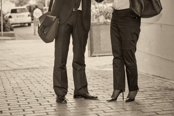 Zakelijke bijeenkomst buiten, twee mensen lopen langs de straten van de stad. Detail op de benen. - Foto, afbeelding