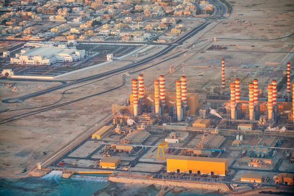 Gebäude und Industrie am Stadtrand von Doha, Blick aus dem Flugzeug im Morgengrauen. - Foto, Bild