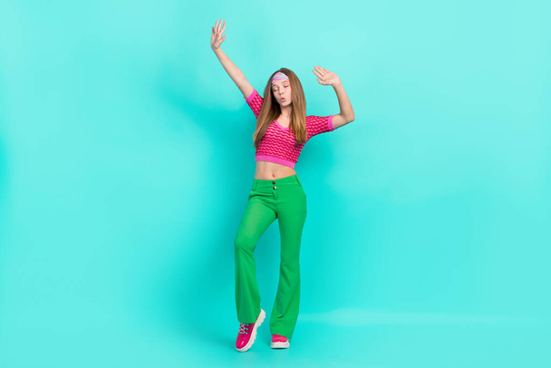 Full length photo of dreamy sweet school girl dressed pink crop top flare trousers having fun dancing isolated teal color background. - Fotografie, Obrázek