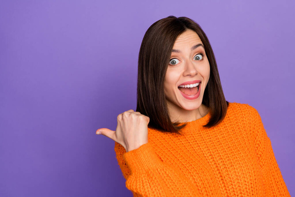 Portrait of astonished cheerful girl indicate thumb finger empty space isolated on purple color background. - Foto, Imagem
