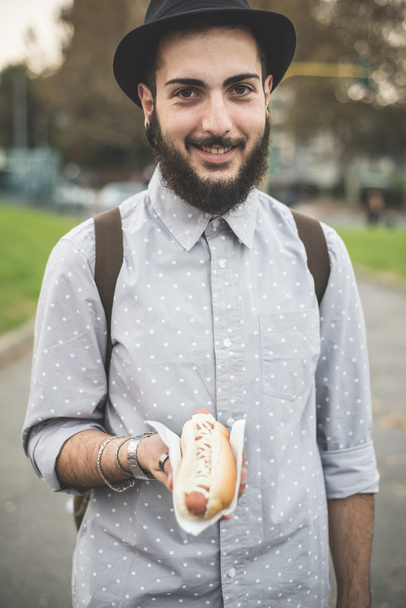 Hipster mies syö hot dog
 - Valokuva, kuva