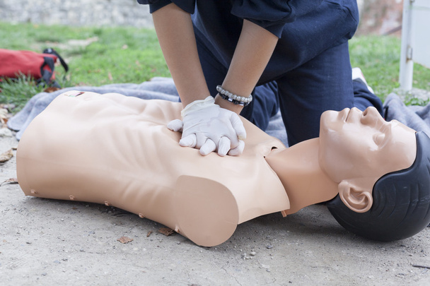 Paramedic demonstrates CPR on a dummy - Photo, image