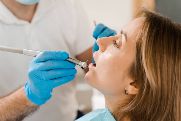 Dental drill close-up. Dentist drilling teeth of woman in dentistry clinic. Teeth treatment. Dental filling for girl patient - Fotó, kép