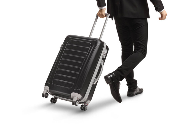 Rear view shot of a man pulling a suitcase isolated on white background - Foto, Bild