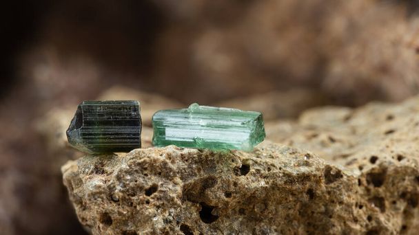 Duas peças de cristal de turmalina azul e verde cru em fundo de pedra áspera em luz natural - Foto, Imagem