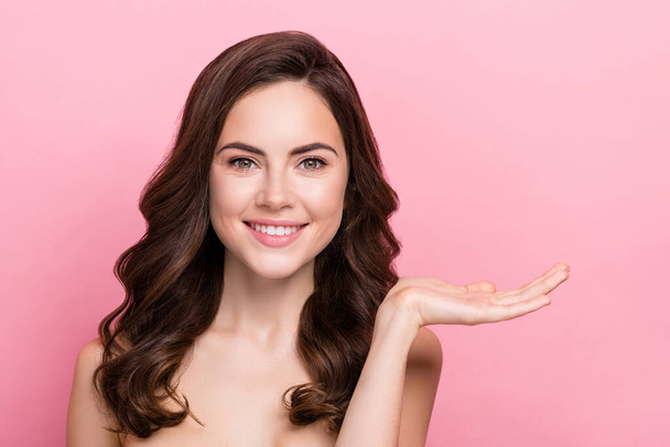 Photo of young adorable woman promoter hold hands lifting moisturizing cream isolated over pink color background. - Fotografie, Obrázek