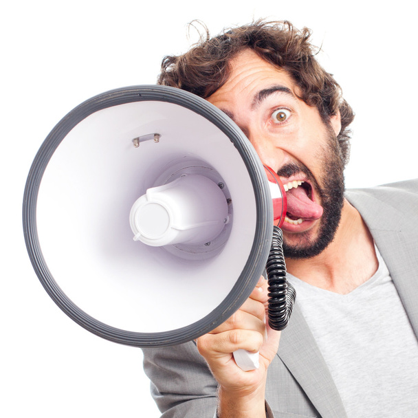 Young crazy man shouting with a megaphone - Фото, изображение