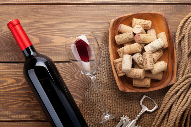 Botella de vino tinto con vidrio y corchos
 - Foto, Imagen